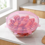 LeakGuard pink stretch lid sealing a glass bowl of strawberries and watermelon