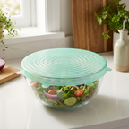 LeakGuard green stretch lid sealing a glass bowl of fresh salad