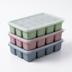 Three LeakGuard silicone ice cube trays stacked with clear snap-on lids in green, pink and blue