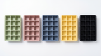 Five LeakGuard silicone ice cube trays in green, pink, blue, yellow and black